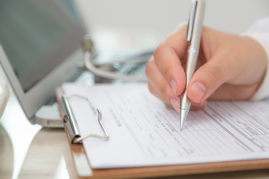 Hand of doctor writing on prescription